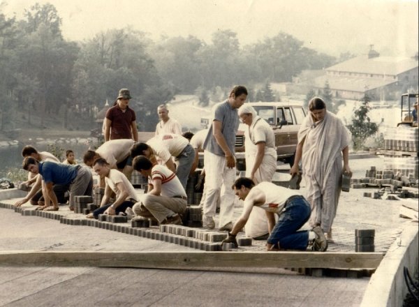 Bhaktipada supervises a brick-laying marathon (1985).